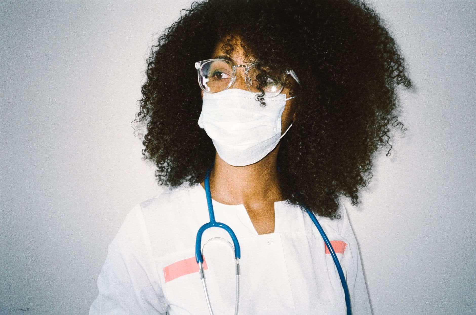 A healthcare professional wearing a protective mask and stethoscope, focused and ready for duty.